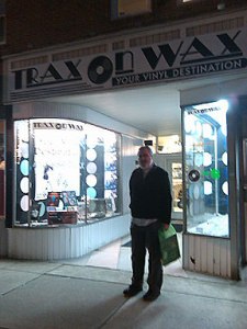 Alan Haber stands beneath the sign at Trax on Wax